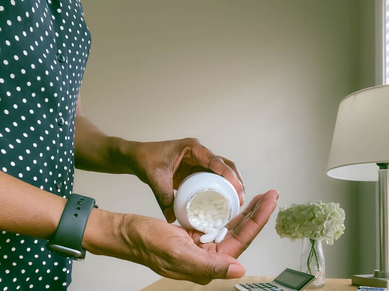 Woman pouring supplements from a bottle for menopause symptoms