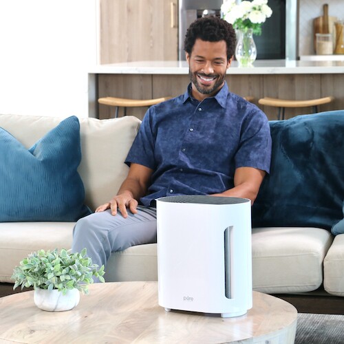 Man in living room, enjoying the air quality thanks to his new air purifier