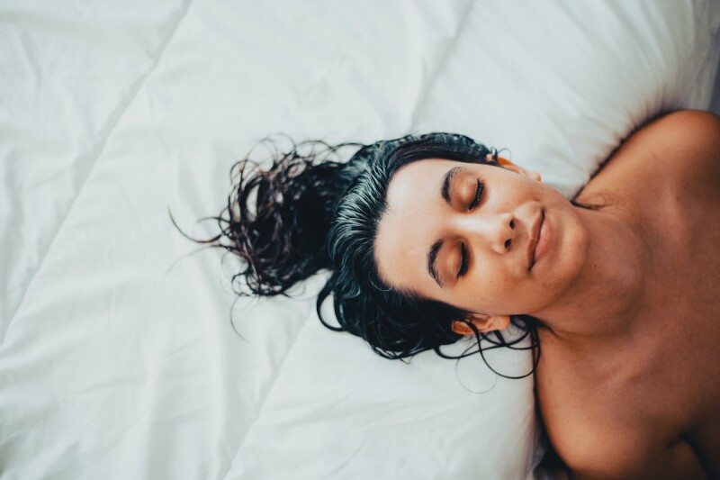 Woman relaxing naked by the bed, feeling confident