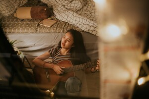 Person with night owl chronotype playing a guitar to relax and meditate at night before bedtime