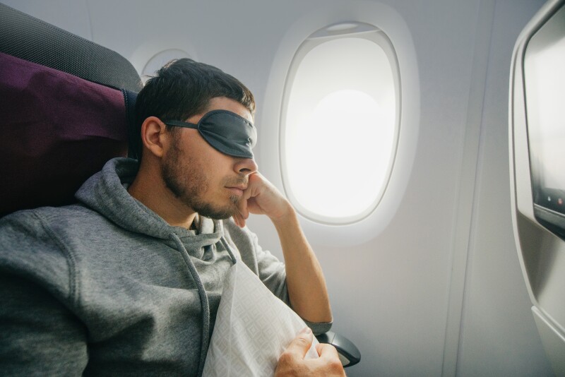 Travel Sleep: Man wearing an eyemask on a plane