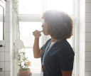 Female healthcare worker brushing teeth in bathroom at home