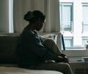 Woman wondering anxiously about the future while sitting in bed