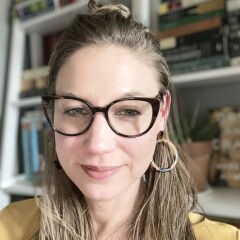 Writer Jennifer Chesak standing in front of a bookshelf.
