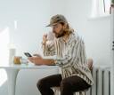 Person drinking coffee in the morning, checking their sleep data from the Sleep.com Sleep Tracking App