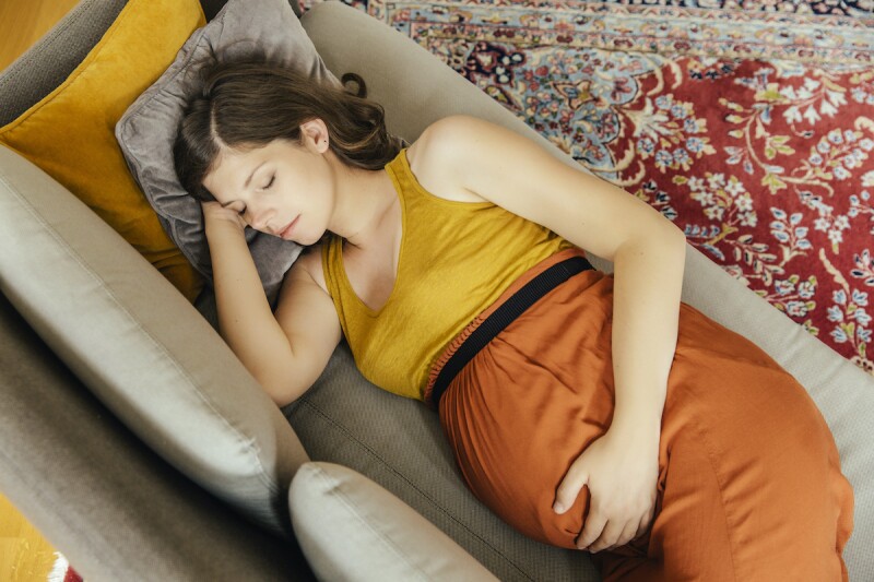 Pregnant woman napping on her left side to aid in acid reflux relief