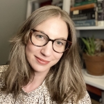 Writer Jennifer Chesak standing in front of a bookshelf.