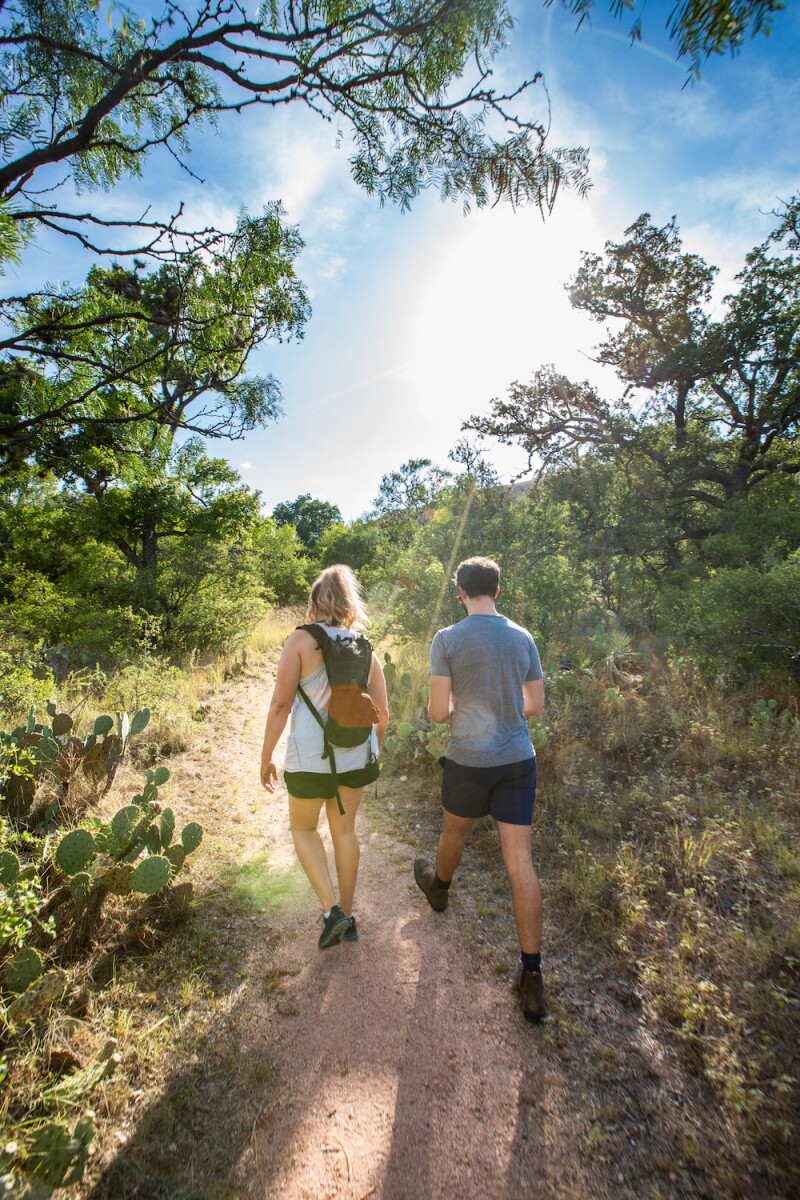 Two friends hiking at Enchanted Rock in Texas.