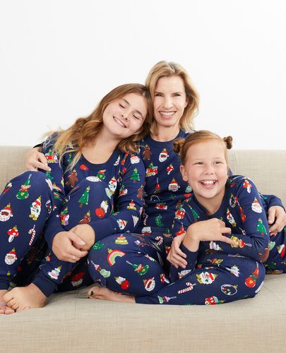 A woman and two young girls laughing in matching Hanna Andersson pajamas.
