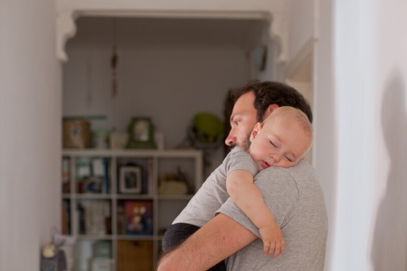 Father holding his toddler for a nap after his wake window