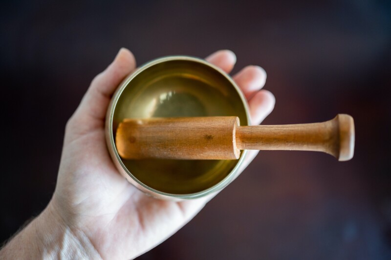 Hand holding a sound bowl for a sound bath environment