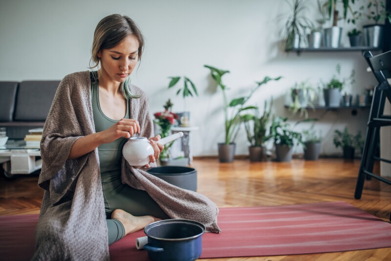 Woman preparing a neti pot for nasal drainage