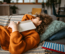 Young pretty student woman napping on the sofa in her living room after studying