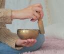 Person ringing a sound bowl in their bedroom for better sleep
