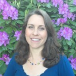 Writer Lisa Fields. She's standing outside in front of purple flowers.