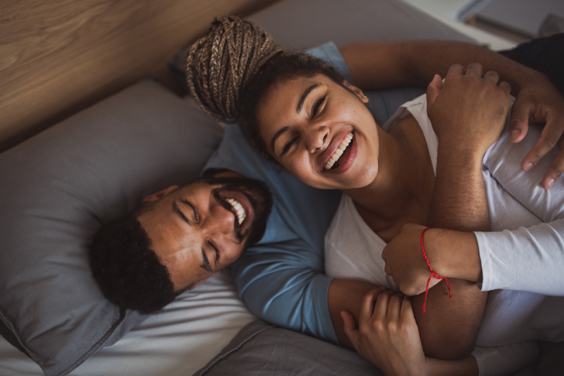 Man and woman resting in bedroom, having fun.